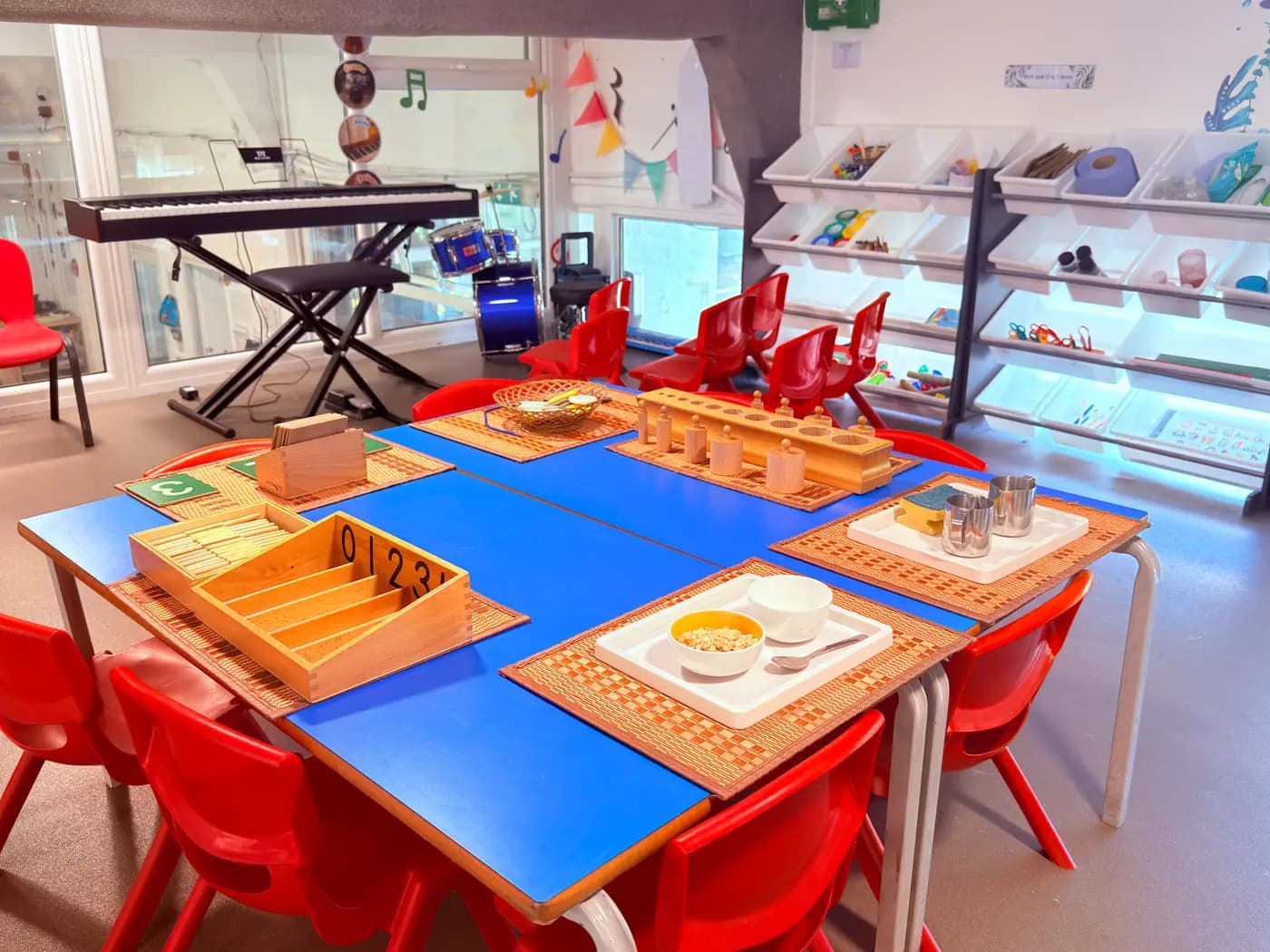 A calm Montessori classroom with wooden materials laid out on low tables